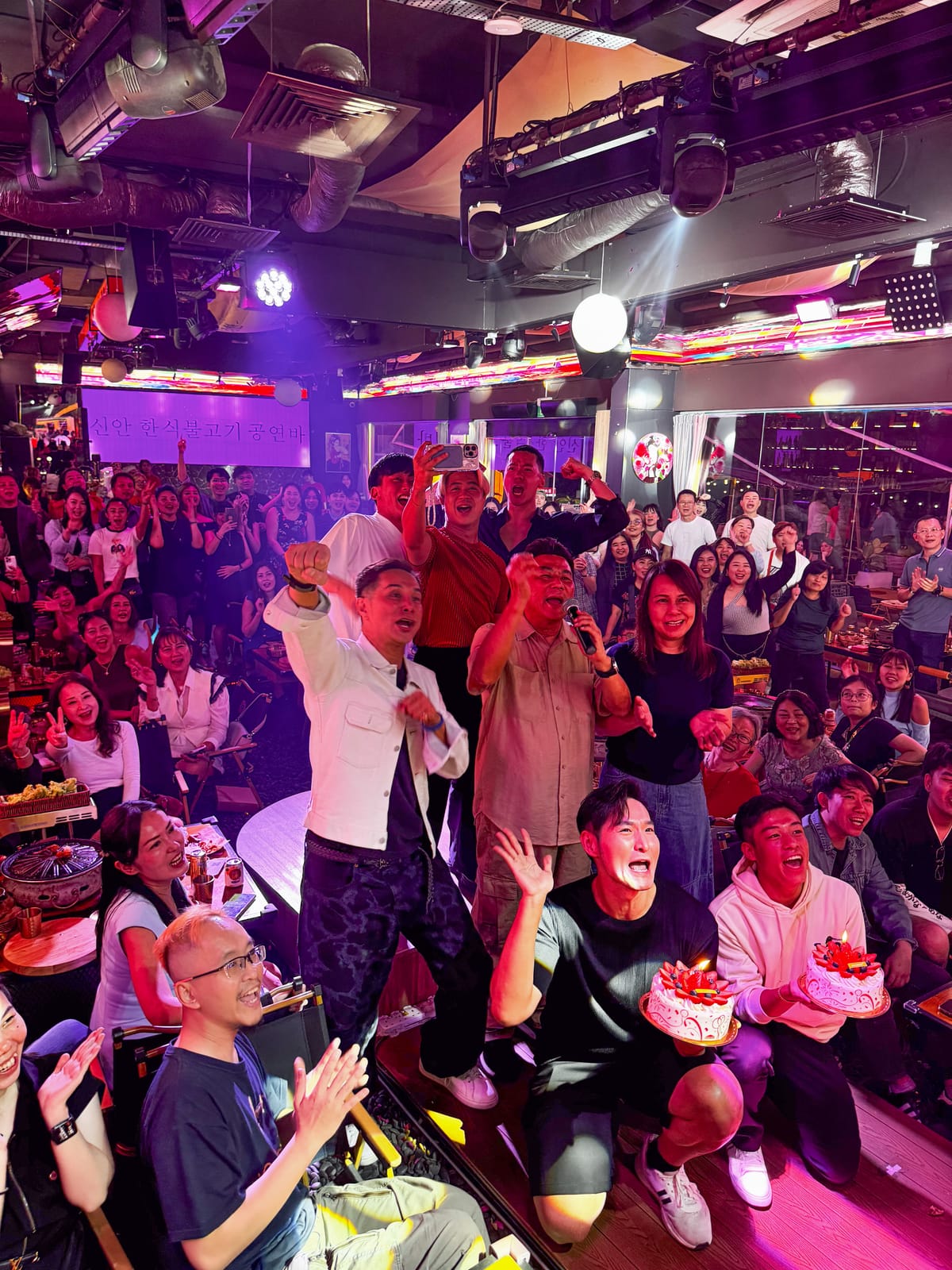A packed crowd cheering during a live celebration at Xin Yan